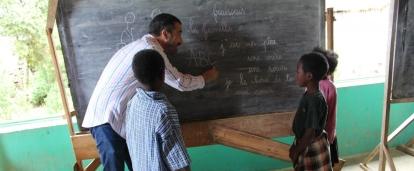 A Projects Abroad volunteer teaching his students on the black board in Madagascar. Students have group lessons with the volunteer teaching in Madagascar.